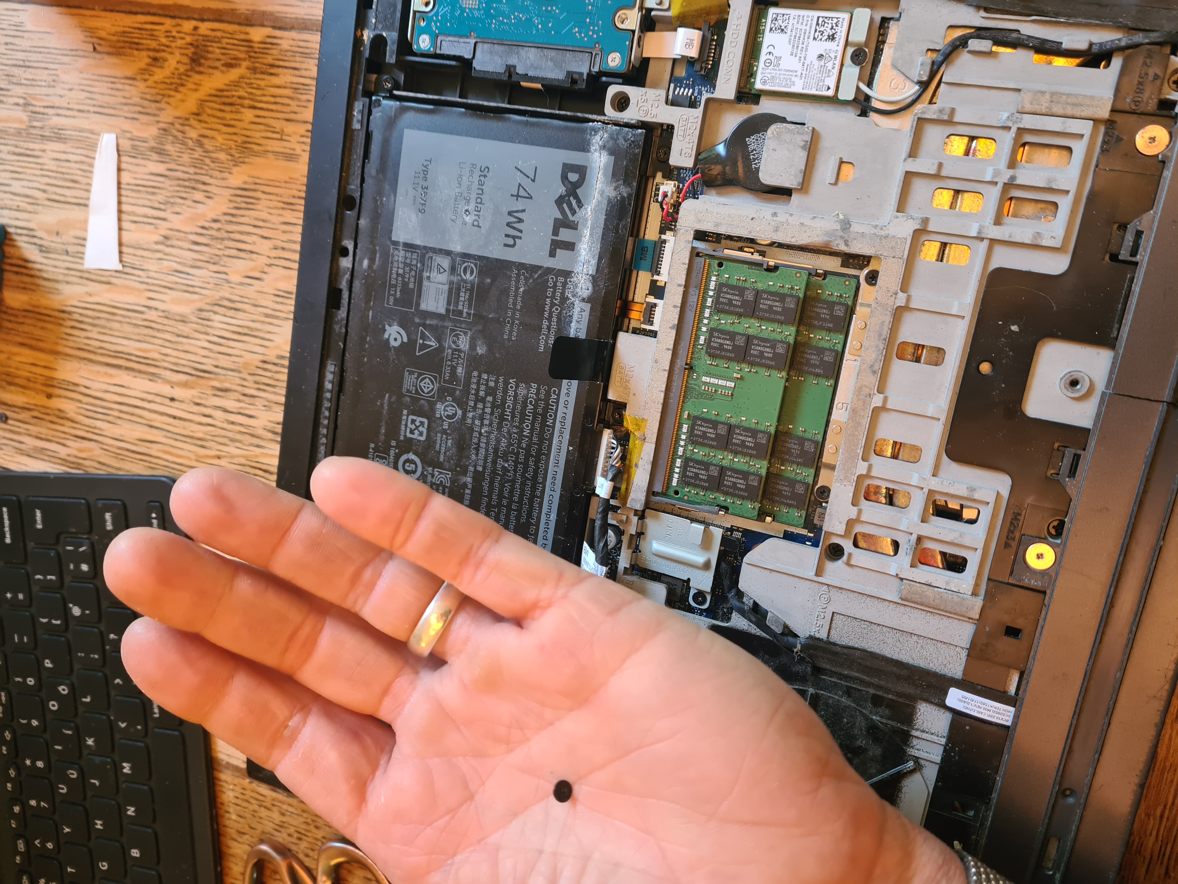 The internals — RAM sticks, battery and SSD visible with the base panel off